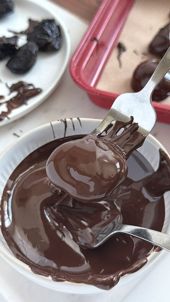 Soaking the prunes in dark chocolate.