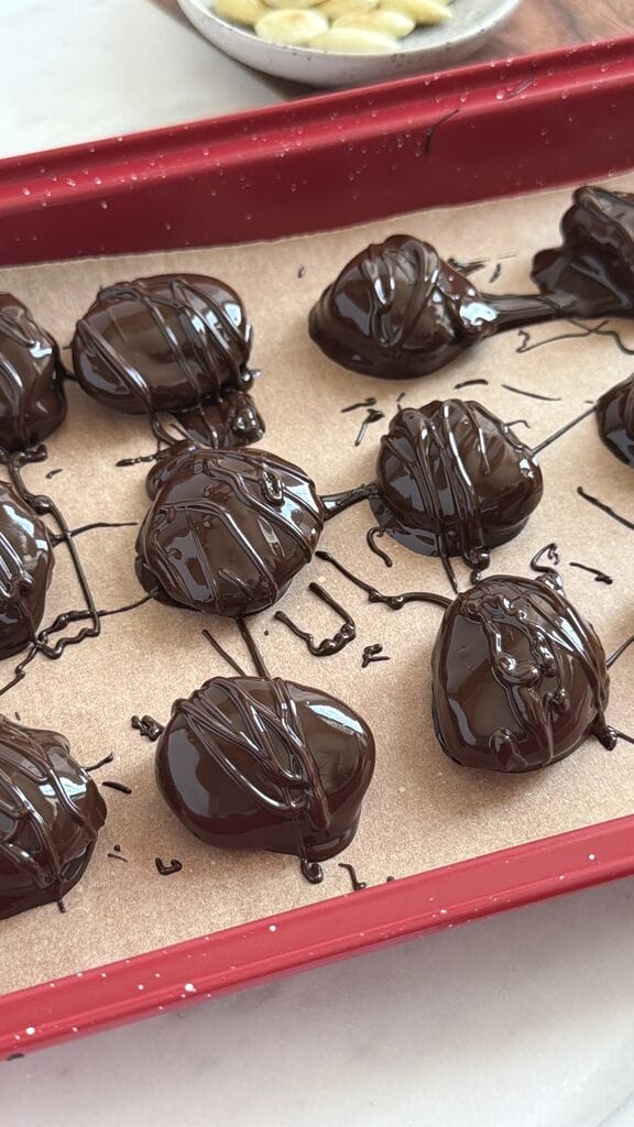 Drizzling chocolate over the prunes.