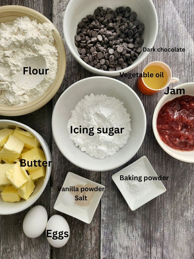 Ingredients include: Flour, Dark chocolate chips, icing sugar, vegetable oil, butter, eggs, baking powder, jam, vanilla powder and salt.