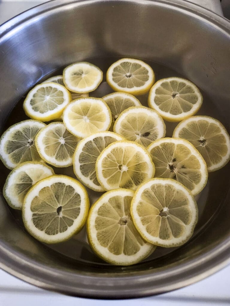 Boiling the lemon slices in water.