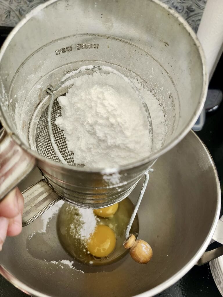 Adding the icing sugar to the eggs.