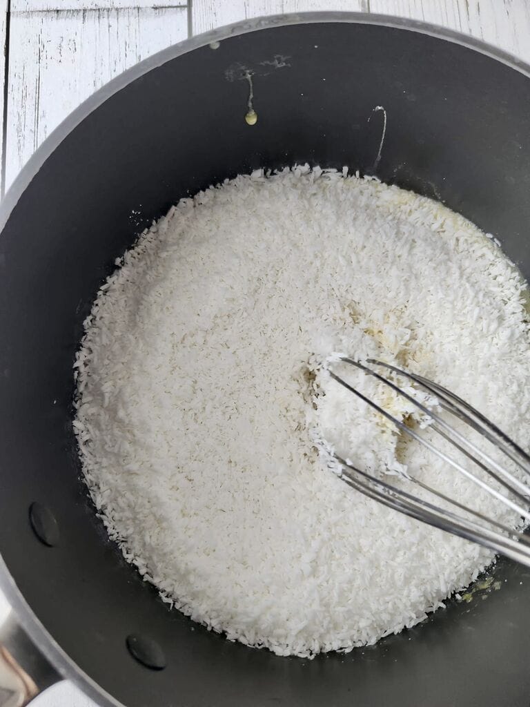 Adding the coconut into the sugar and egg mixture.
