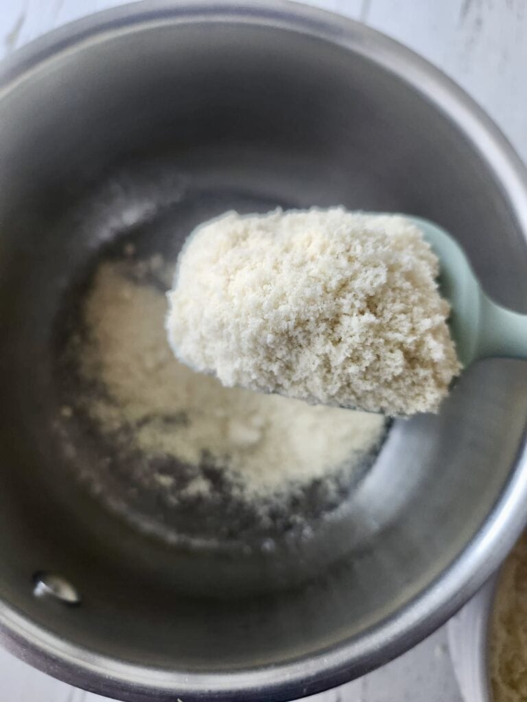 The almond flour being added to the syrup.