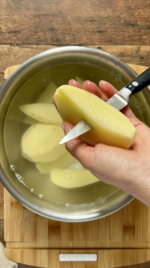 Cutting potatoes in wedges.