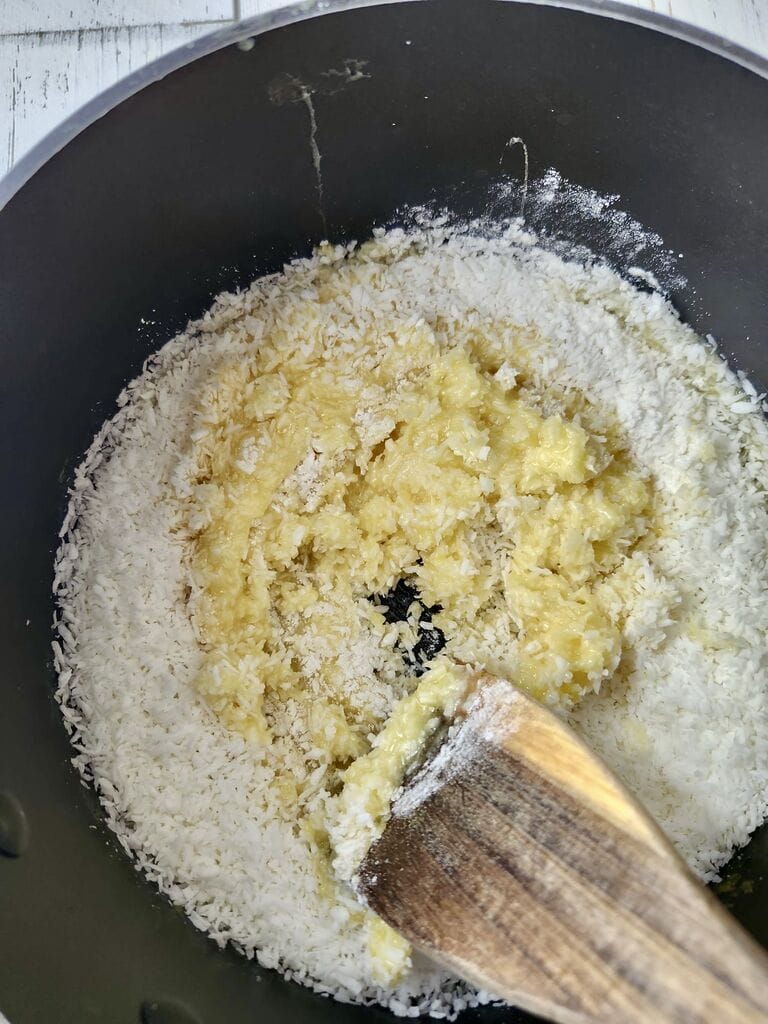 Adding the coconut to the egg and sugar mixture.