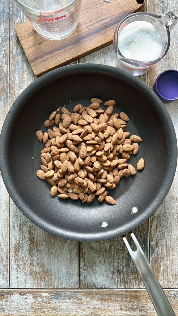 Adding the almonds to the frying pan.