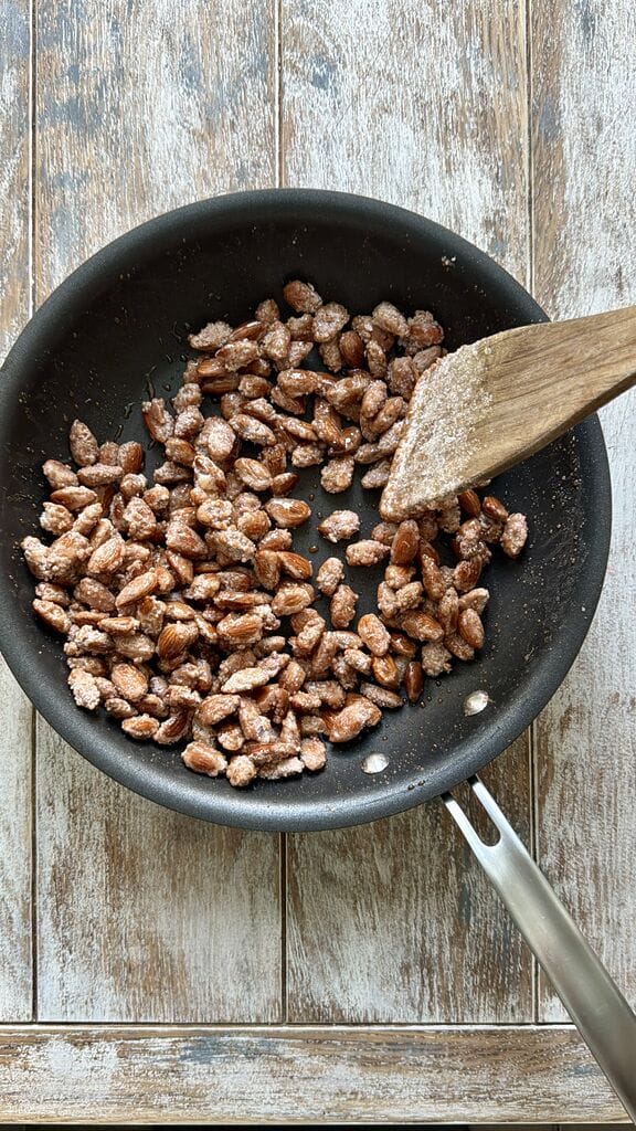 Stirring the almonds, until they caramelize.