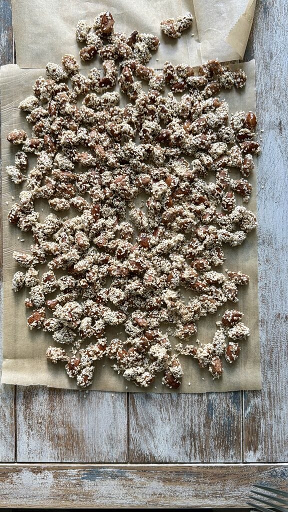 Spreading out the caramelized almonds, so they can separate and cool.