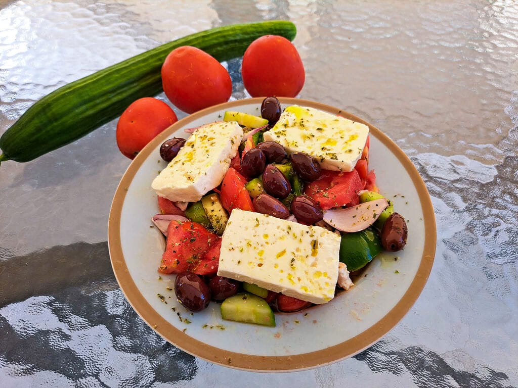 A horiatiki salad topped with Sfela cheese.
