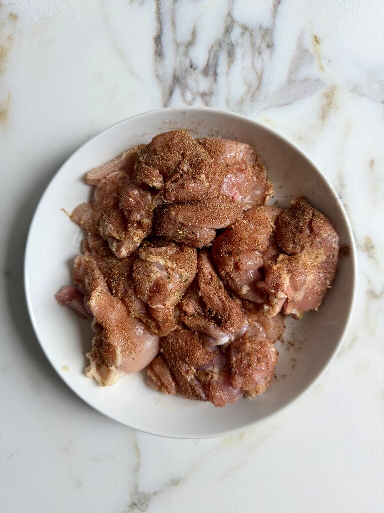 Marinating the chicken thighs in the spices.