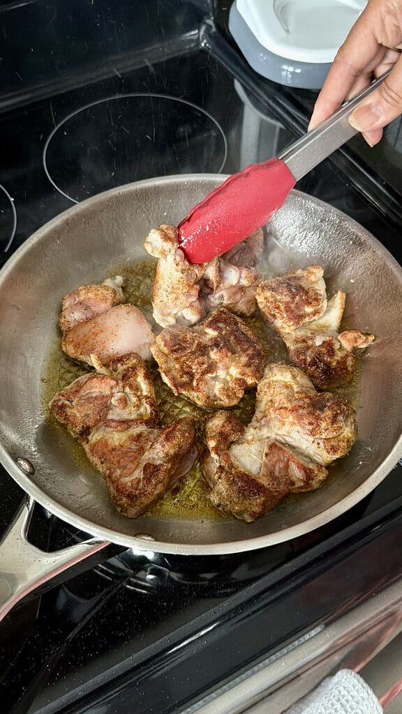Frying the chicken thighs.