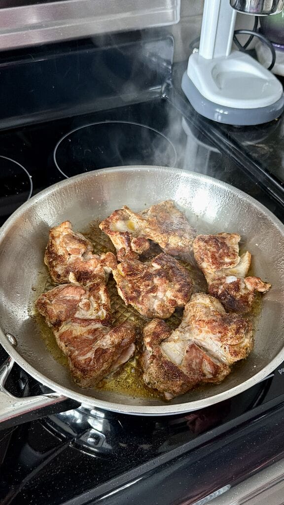 Frying the chicken thighs.