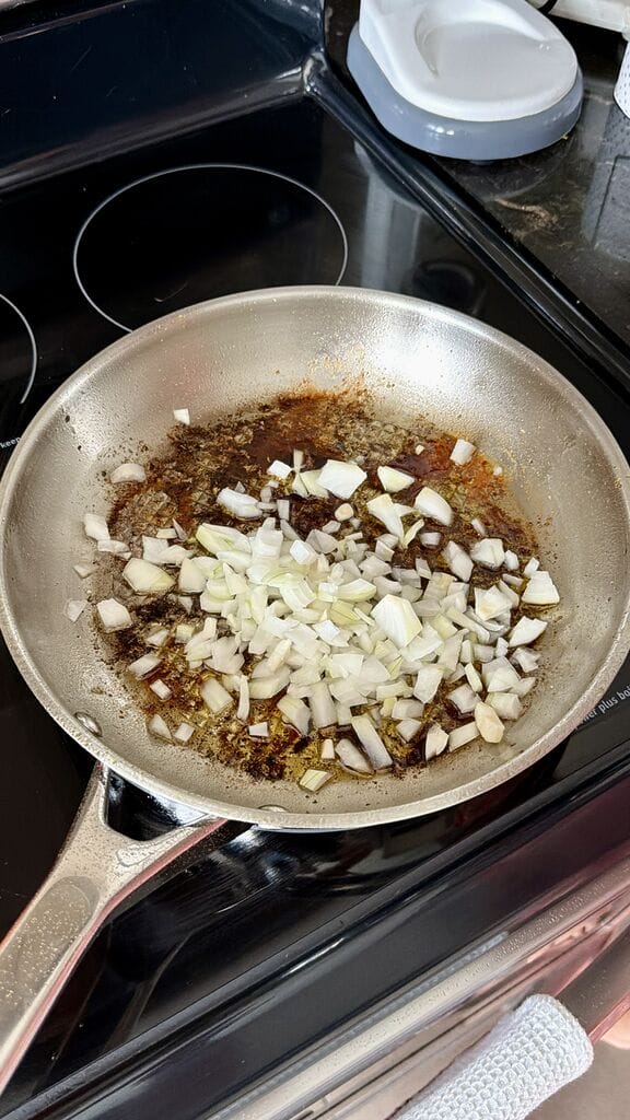 Adding the chopped onions to frying pan.