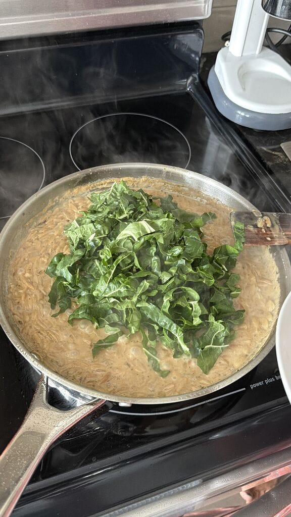 Adding the swiss chard to the frying pan.