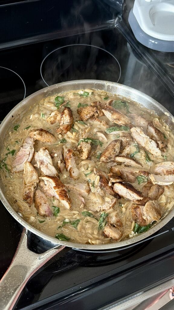 Creamy Lemon Chicken Orzo Recipe with Swiss Chard and Feta in a stainless steel frying pan.