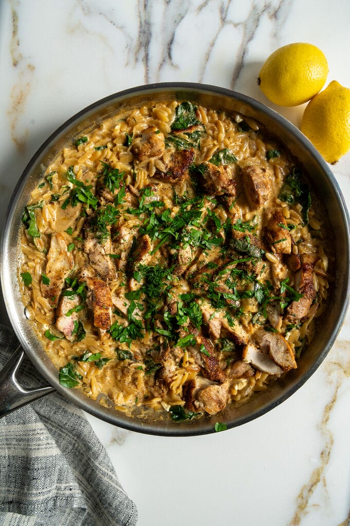 Creamy Lemon Chicken Orzo Recipe with Swiss Chard and Feta in a stainless steel frying pan.