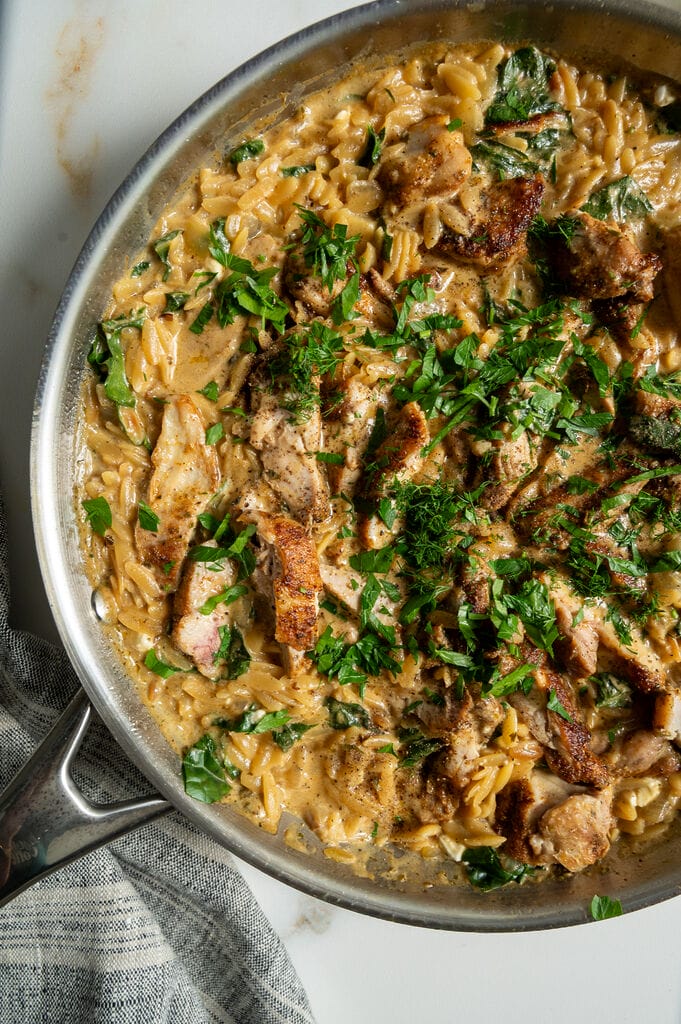Creamy Lemon Chicken Orzo Recipe with Swiss Chard and Feta in a stainless steel frying pan.