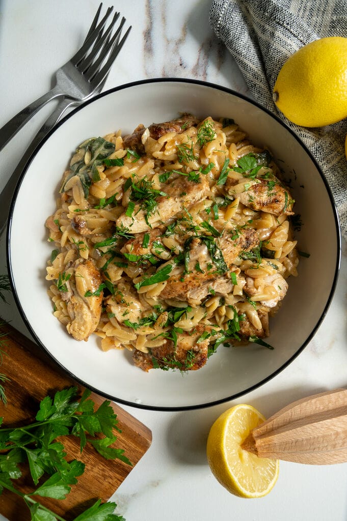 Creamy Lemon Chicken Orzo Recipe with Swiss Chard and Feta in a white bowl.