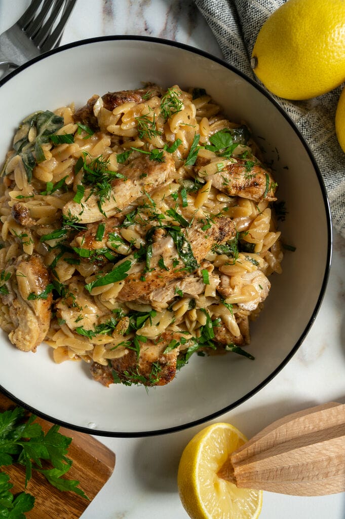Creamy Lemon Chicken Orzo Recipe with Swiss Chard and Feta in a white bowl.