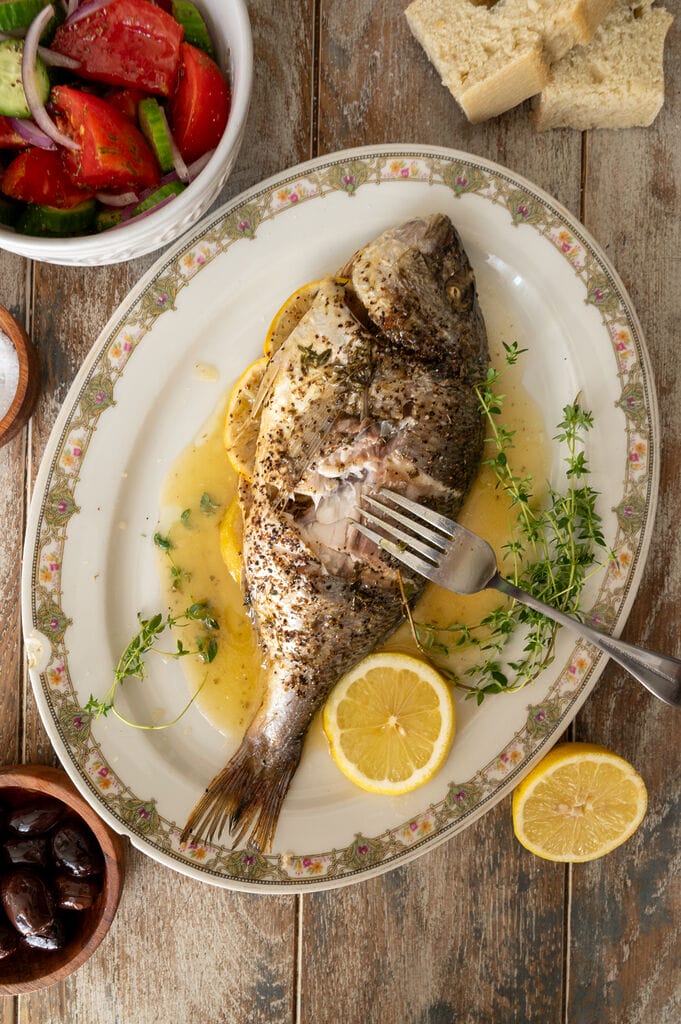 Cutting into the fish, and showing some of its meaty flesh.
