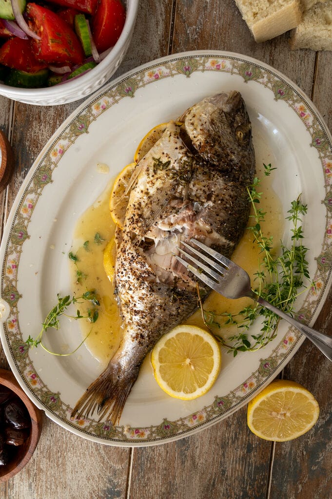 Cutting into the fish, and showing some of its meaty flesh.